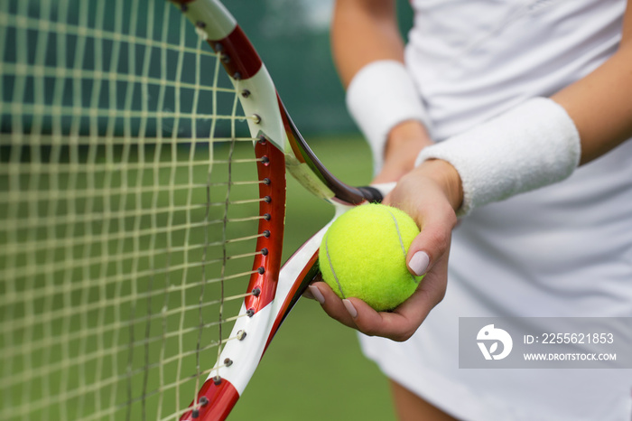 Tennis player holding racket and ball in hands