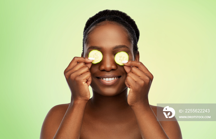 美容、护肤和排毒概念-美丽的非裔美国妇女用黄瓜制作眼罩