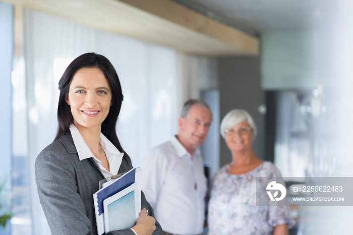 Portrait confident female financial advisor meeting with senior couple