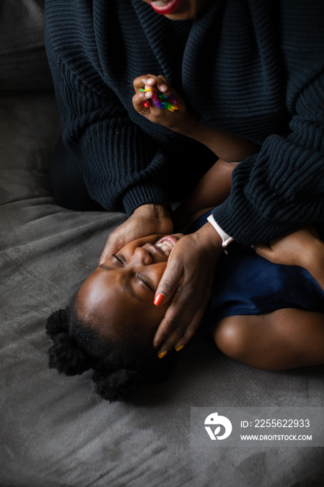 African American mom holding daughters smiling face