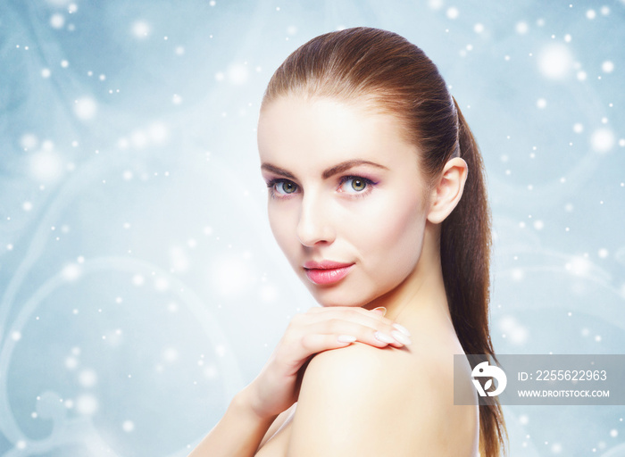 Portrait of young, beautiful and healthy woman over winter Christmas background.