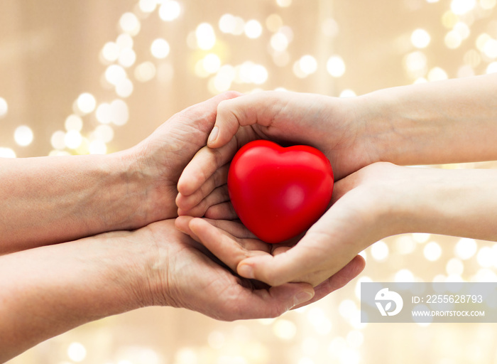 people, age, family, love and health care concept - close up of senior woman and young man hands hol