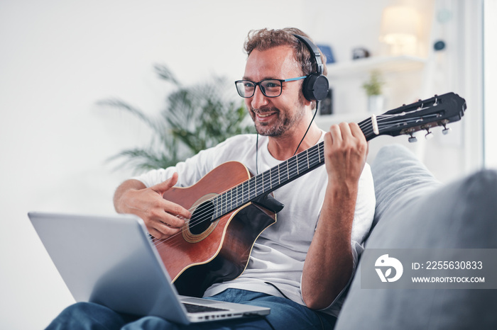 Man playing acoustic guitar in the living room.