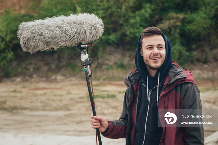 Behind the scene. Sound boom operator hold microphone fisher outdoor