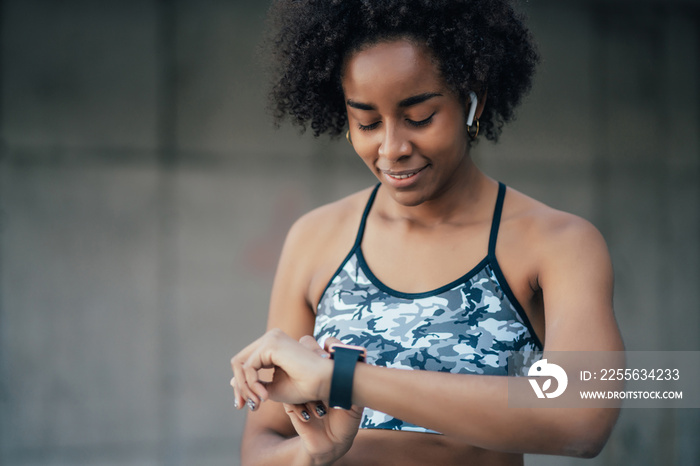 Fitness woman checking time on smart watch.