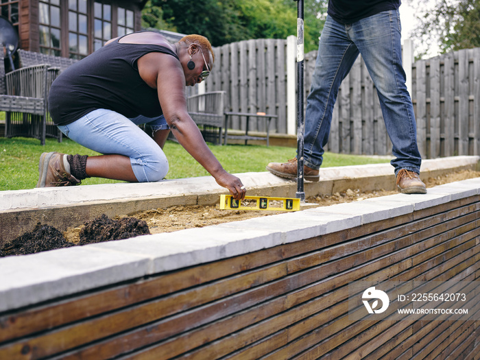 Couple doing construction work in backyard