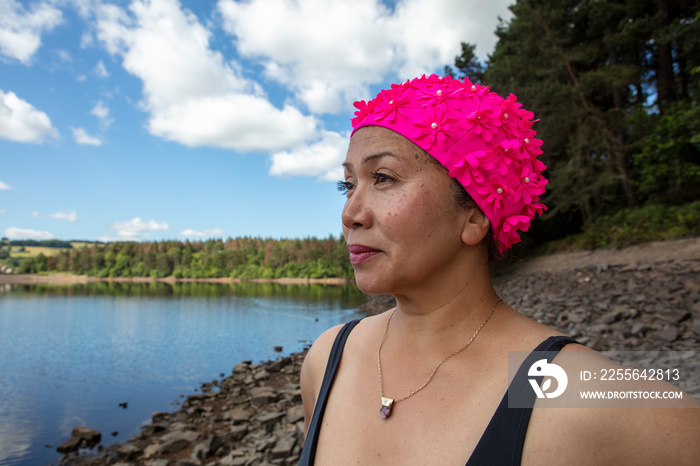 英国约克郡，一名戴粉色泳帽的女子站在岩石湖岸