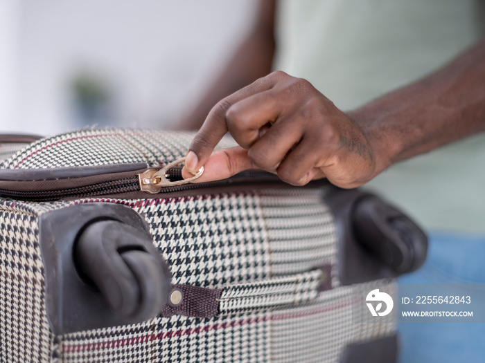 Close-up�of person zipping suitcase