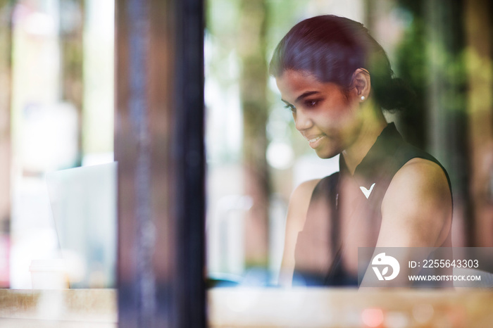 Woman with laptop sitting in cafe