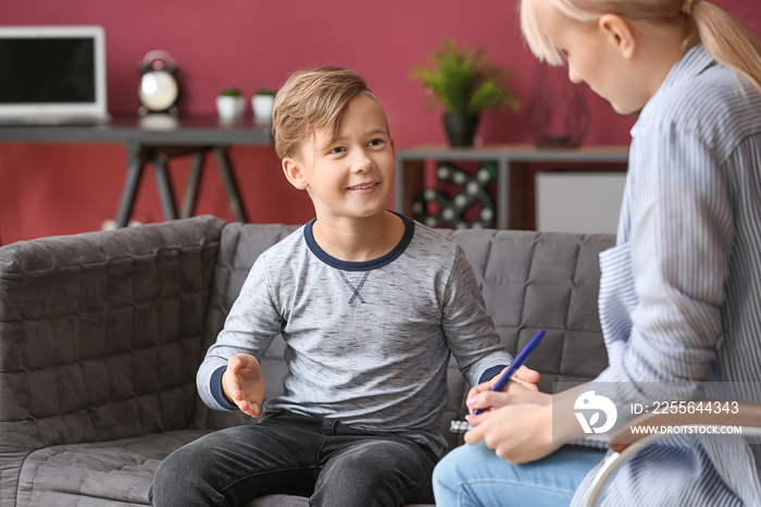 Female psychologist working with little boy in office