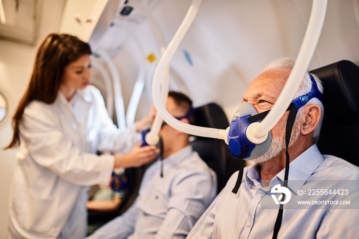 Senior man receiving hyperbaric oxygen therapy.