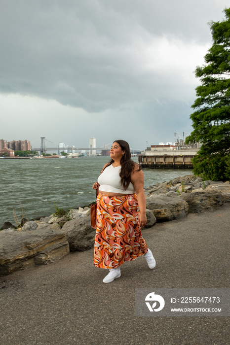 USA, New York City,�Young woman walking by river