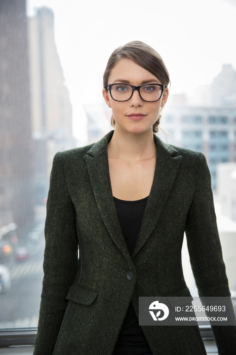 Portrait of businesswoman standing by window