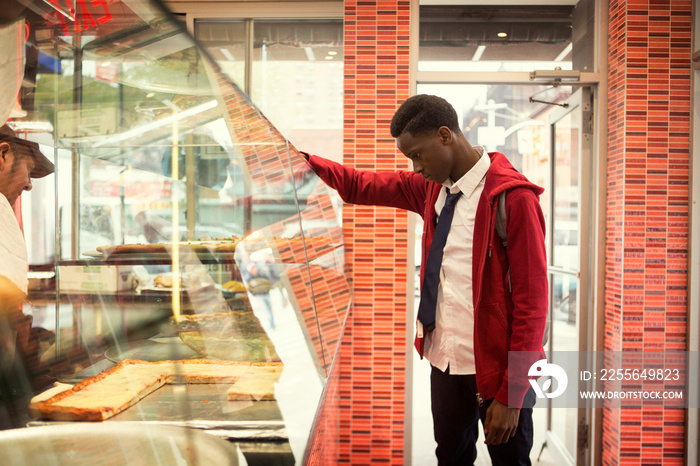 Teenage boy (14-15) choosing food in bakery