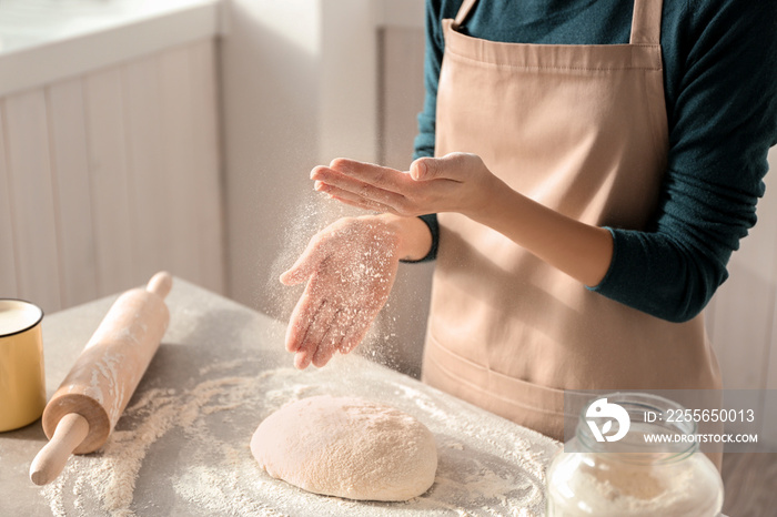 Woman preparing dough at table in kitchen