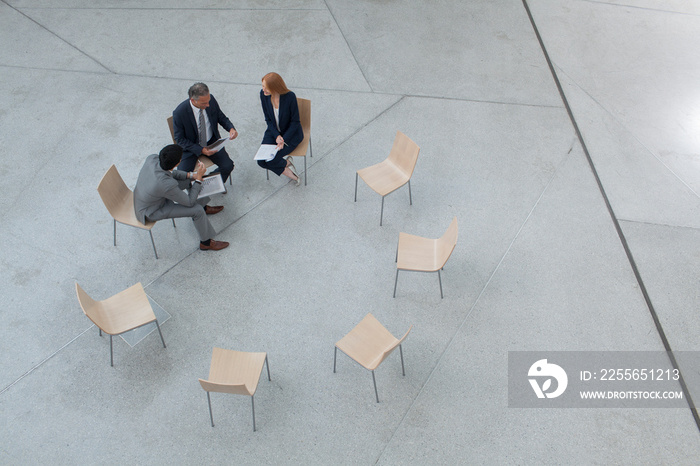 Business people meeting in circle of chairs