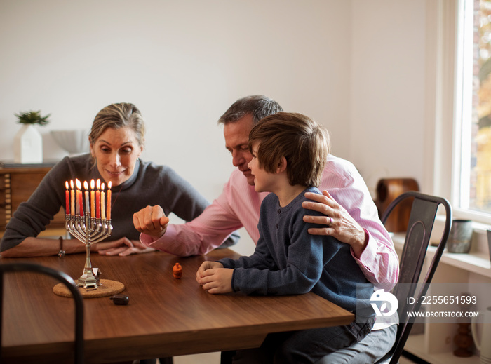 Grandparents playing with grandson during Hanukkah festival at home