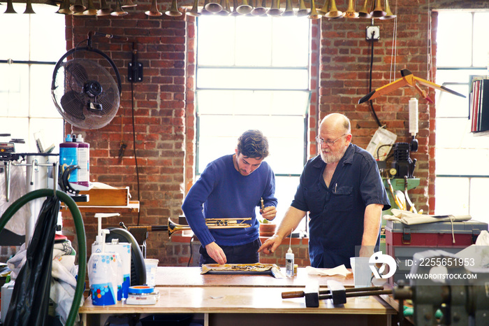 Workers making trumpet in workshop