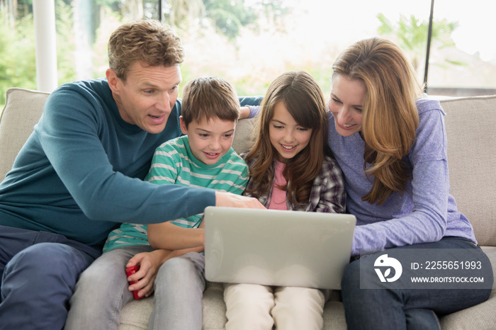 Family using laptop on sofa