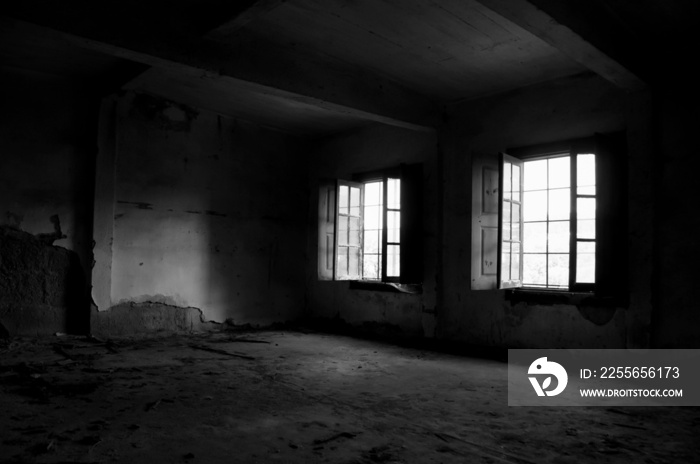 Natural light enters in an abandoned building and ruins in black and white