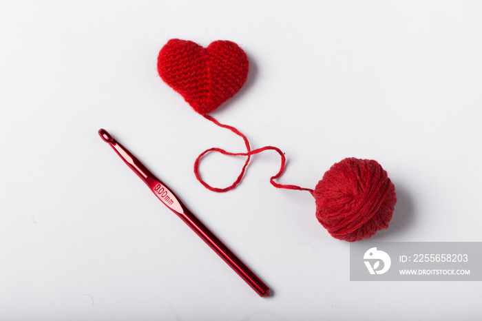 Close up of a wool ball and heart shape on white background. Hea