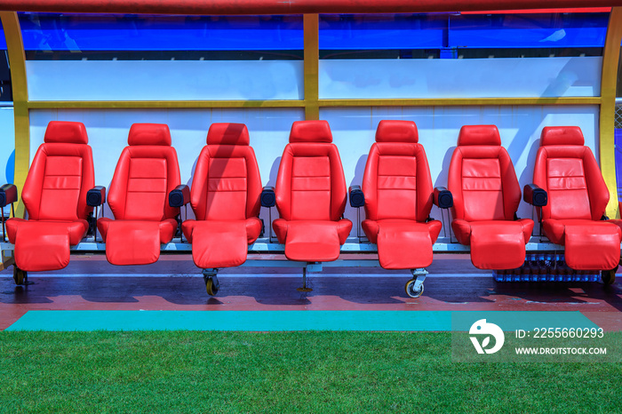 足球场工作人员教练的红色长椅或座椅或椅子的前视图。