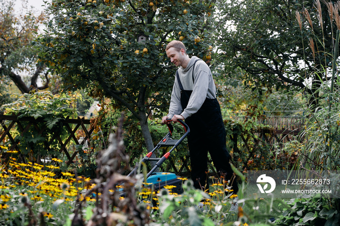 Young man mowing the lawn