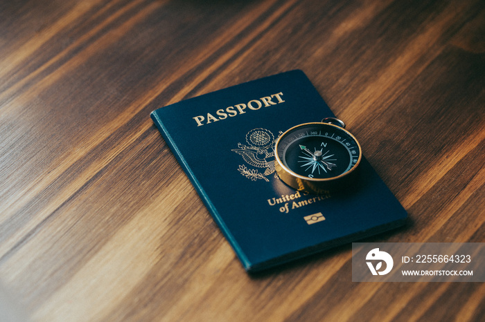 One gold compass on top of a blue American passport