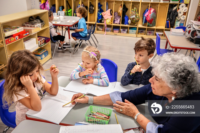 Teacher helping children with their classwork