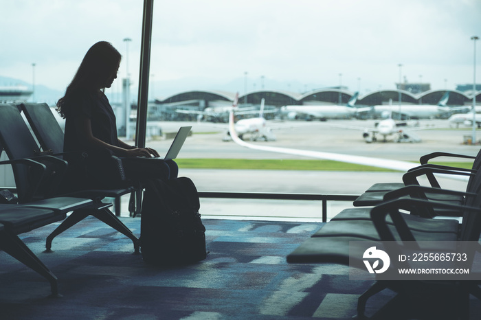 A woman traveler using laptop computer while sitting in the airport