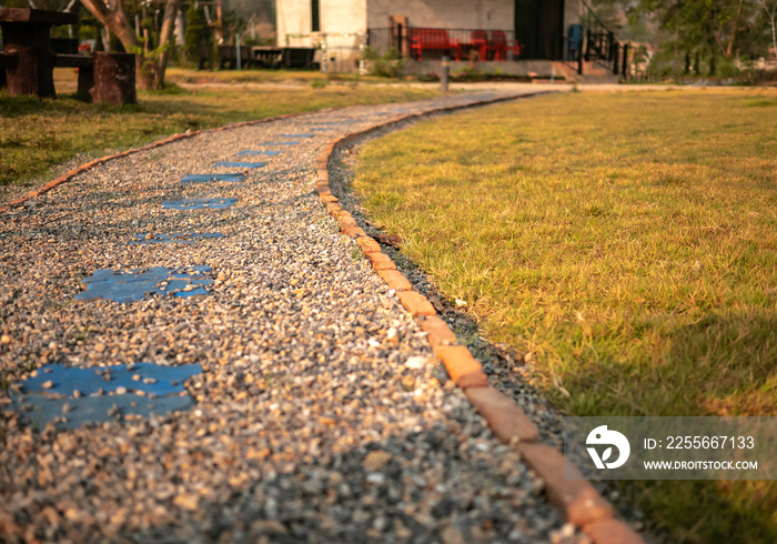 The path to the garden is made of small brown and white stone, Background of stone walk texture.