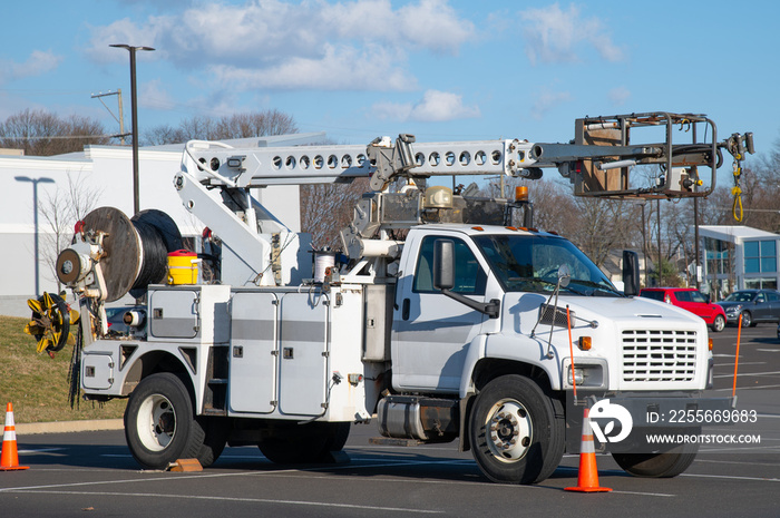 Front and side view of parked communication utility trucks in residential neighborhood