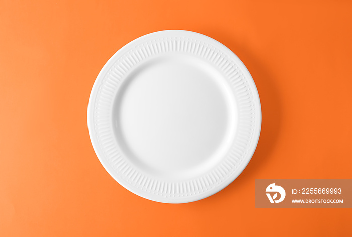 Empty ceramic plate on color background