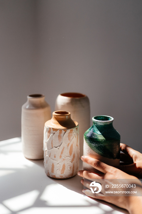 minimalist handmade clay vases on a white background with daylight