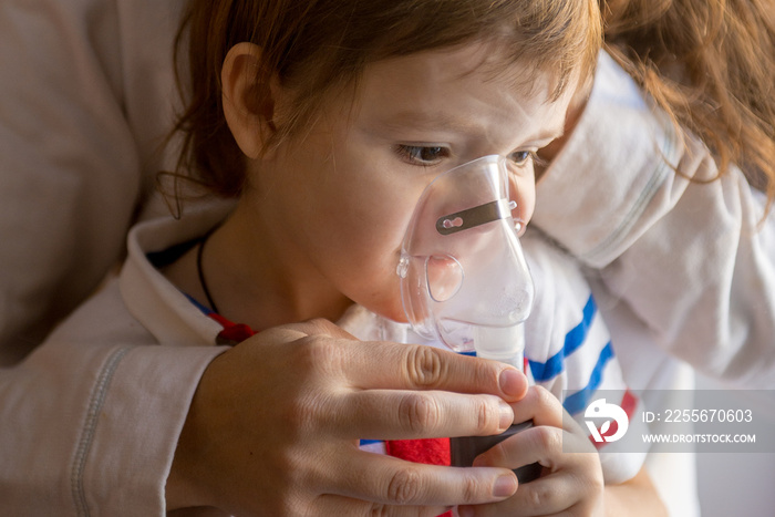 Young woman with son doing inhalation a nebulizer at home