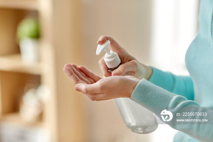 hygiene, health care and safety concept - close up of woman applying antibacterial hand sanitizer