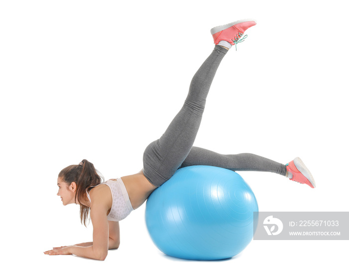 Young sporty woman doing exercises with fitball on white background