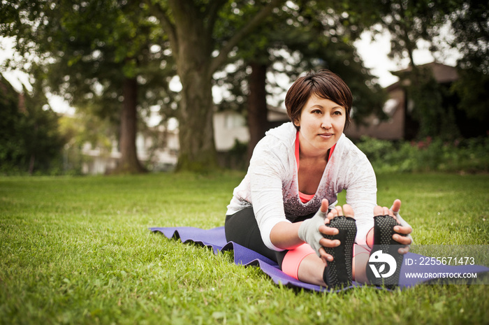 Young woman stretching in park