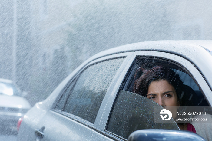 Concerned woman driving car in rain