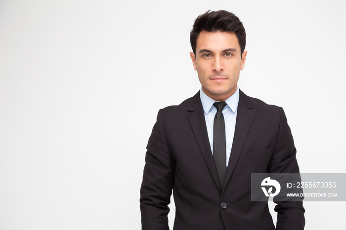 Portrait of a charming businessman dressed in suit and looking at camera isolated over white backgro