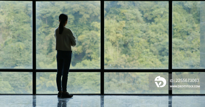 Businesswoman walk to the glass window