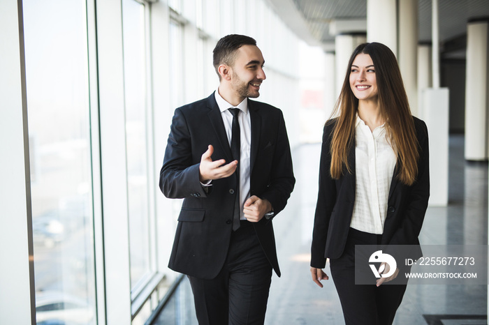 Confident business partners walking down in office and talking