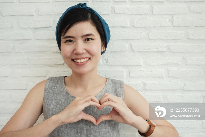 Happy Asian young woman making her hands in heart shape, heart health insurance,csr,  social respons