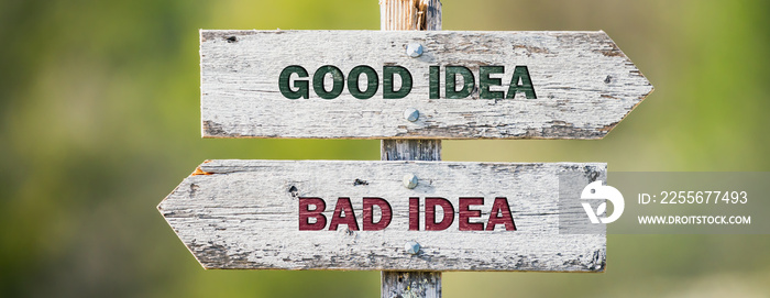 opposite signs on wooden signpost with the text quote good idea bad idea engraved. Web banner format