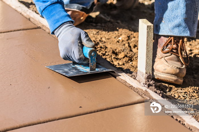 Construction Worker Using Hand Groover On Wet Cement Forming Coping Around New Pool