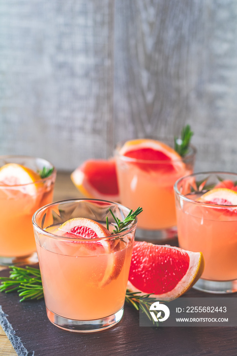 Fresh pink alcoholic cocktail with grapefruit, ice and rosemary