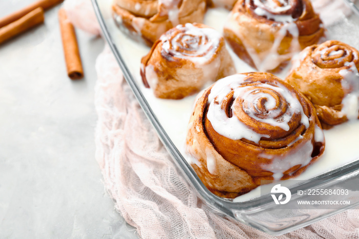 Baking tray with tasty cinnamon buns on table