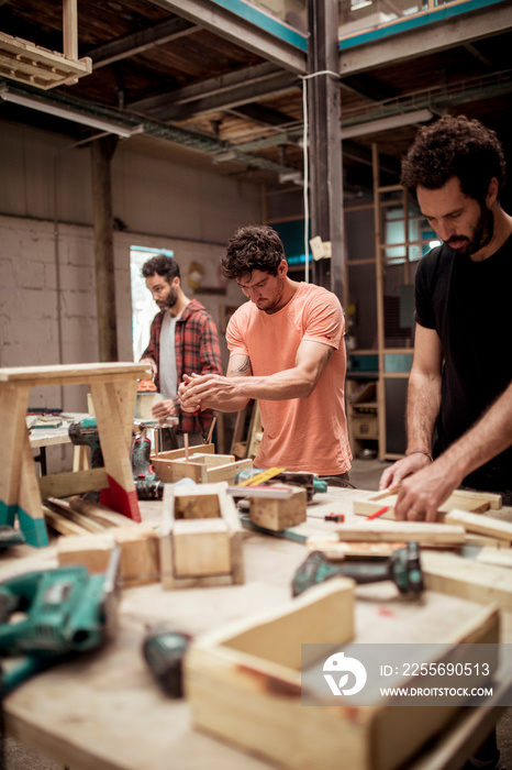 Male carpenters working at workbench in workshop