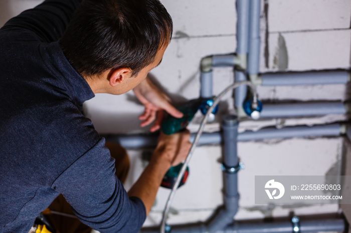 Close-up Of A Male Plumber repairs pipes in the toilet