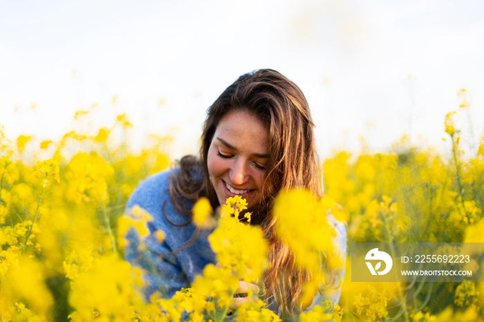 A happy girl in a meadow of yellow flowers